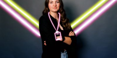 Woman standing on background with neon lines behind her
