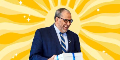 A photo of President Lachemi surrounded by an illustration of the sun beaming behind him.