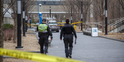 Police officers walking passing the caution tape onto the scene of the crime on Nelson Mandela Walk regarding the hit-and-run