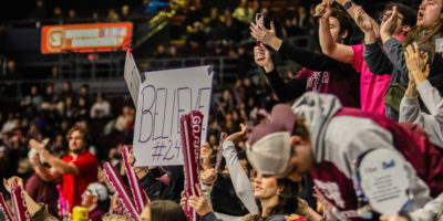 Ottawa Gee-Gees fans cheering in the crowd with a "Believe" sign