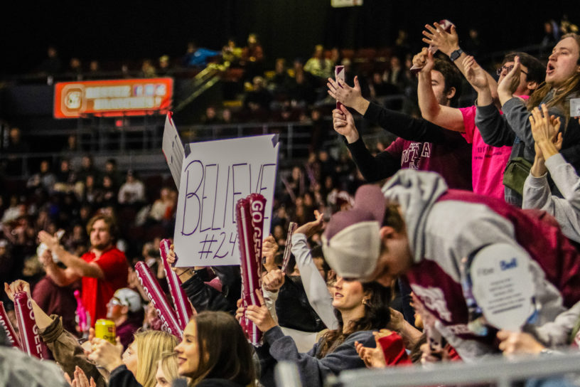 Ottawa Gee-Gees fans cheering in the crowd with a "Believe" sign