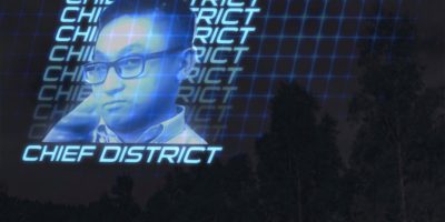 An illuminated blue hologram is projected onto the sky of a forest, featuring an image of Eyeopener Editor-in-Chief Joshua Chang