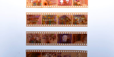 An image of film negatives with small drawings of summer and movie related objects and activities on top.