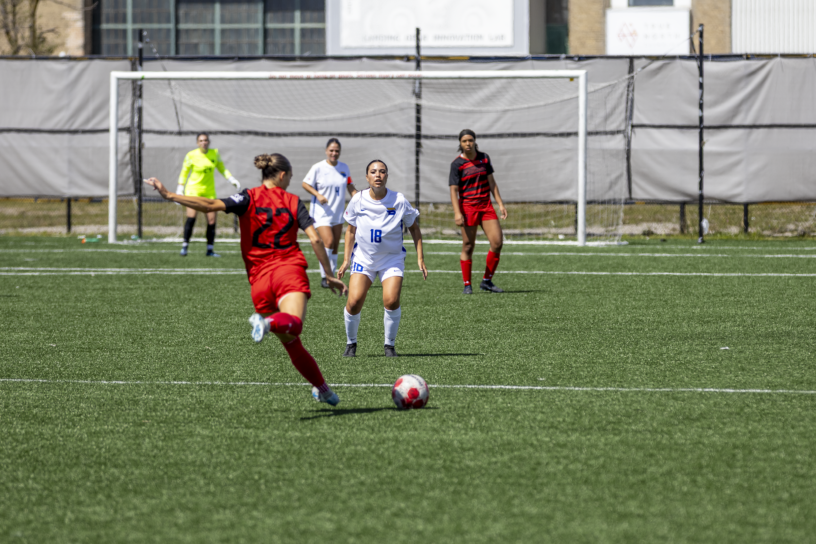 A soccer player prepares to kick a ball towards a net