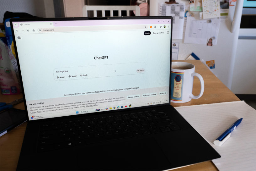 Picture of black laptop on a desk with the AI website, “ChatGPT” open.