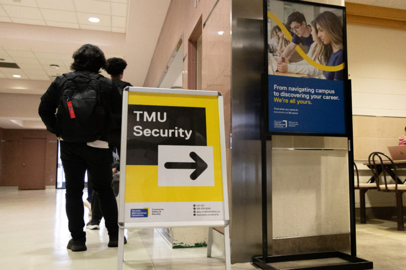 Photo of TMU security sign in a hallway.