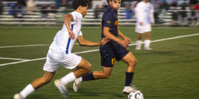 Two opposing soccer players race to the ball