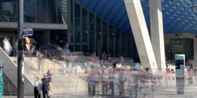 Picture of the Sheldon Levy Centre (SLC) with blurred people walking up and down the stairs.