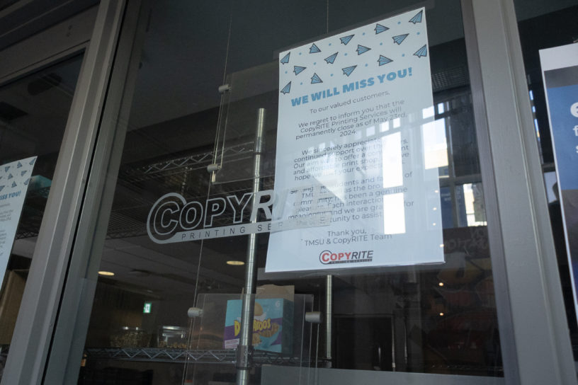 Picture of a storefront window with the words “Copyrite” on the window. A piece of paper saying “WE WILL MISS YOU” is taped on the back of the window.
