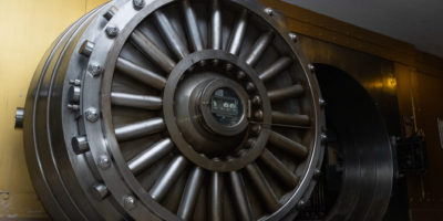 An image of a large bank vault door slightly ajar.
