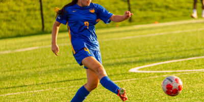 A TMU soccer player kicks the ball