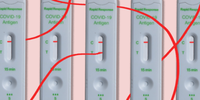 Five COVID-19 rapid test devices. One is positive and has a line extending from the positive line around the other tests.