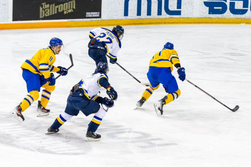 TMU and Lakehead players scurry along the ice