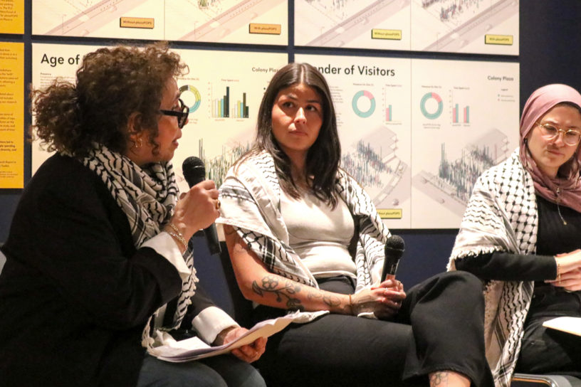 Image of three people sitting on a blue couch talking into microphones.