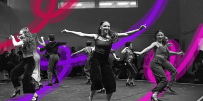 Black and white image of people dancing with their arms out, they are all smiling. There are red, purple and pink line illustrations in the background.