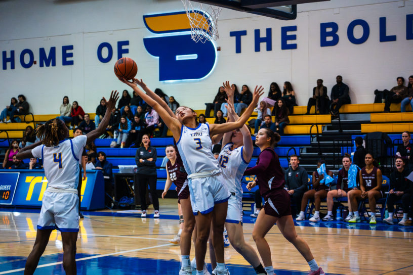 A women's basketball player attempts to gain possession