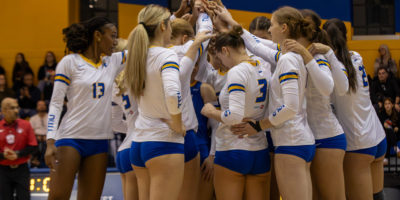 The TMU Bold women's volleyball team in a huddle before a game at the Mattamy Athletics Centre