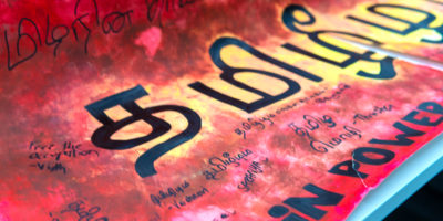 Image of a red and yellow painted poster with black text on it.