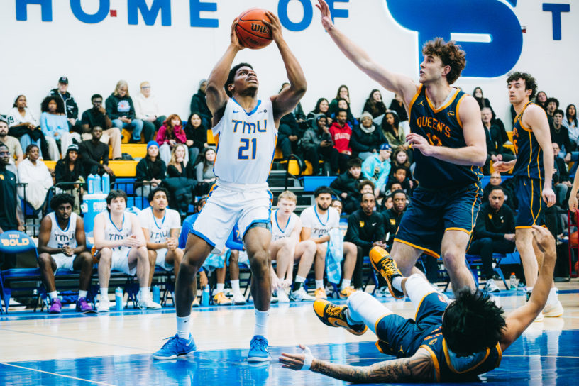 TMU attempts a shot amidst Queen's defence