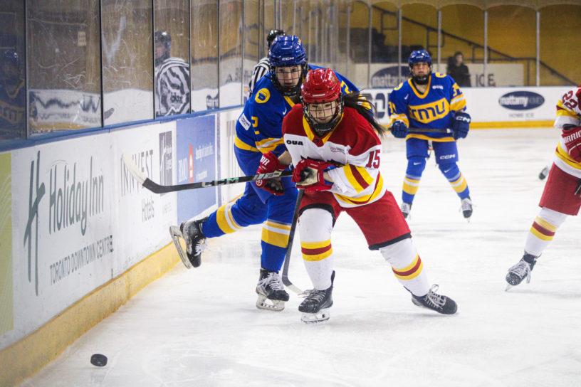 TMU and Guelph both rush to the puck along the boards