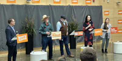 Avi Lewis, Tony McQuail, Rob Ashton, Heather McPherson and Tanille Johnson stand in front of a gray tarp.