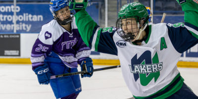A Nipissing women’s hockey player celebrates a goal in front of a TMU player at the Mattamy Athletic Centre